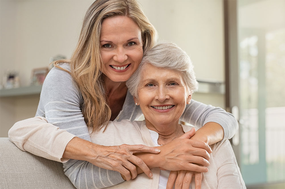 Daughter embracing her elderly mother